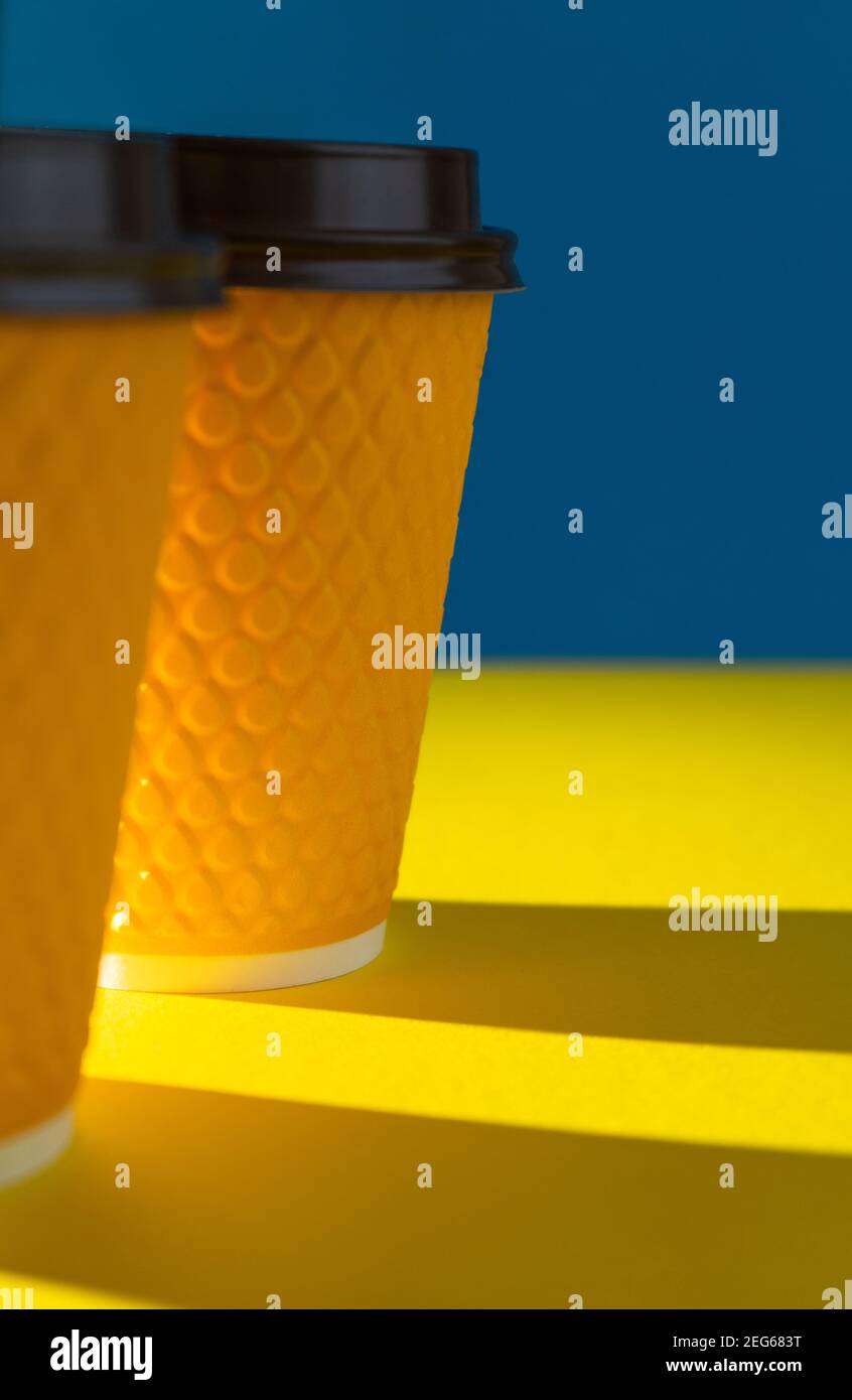 Tazza di carta a coste gialle con coperchio in plastica per bevande da asporto nei fast food. Una tazza di caffè, cacao, tè da un caffè di strada. Posto per voi Foto Stock