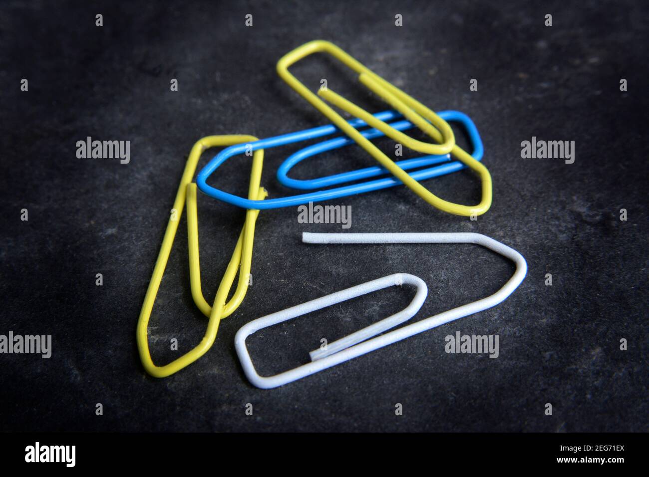 Graffette colorate disposte su una superficie scura che mostrano vivaci sfumature di giallo, blu e bianco in un display creativo Foto Stock