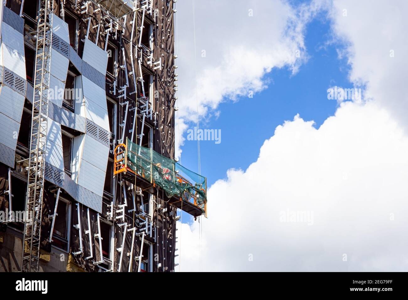 Lavoratori costruttori che installano finestre di vetro sulla facciata dell'edificio d'affari Foto Stock