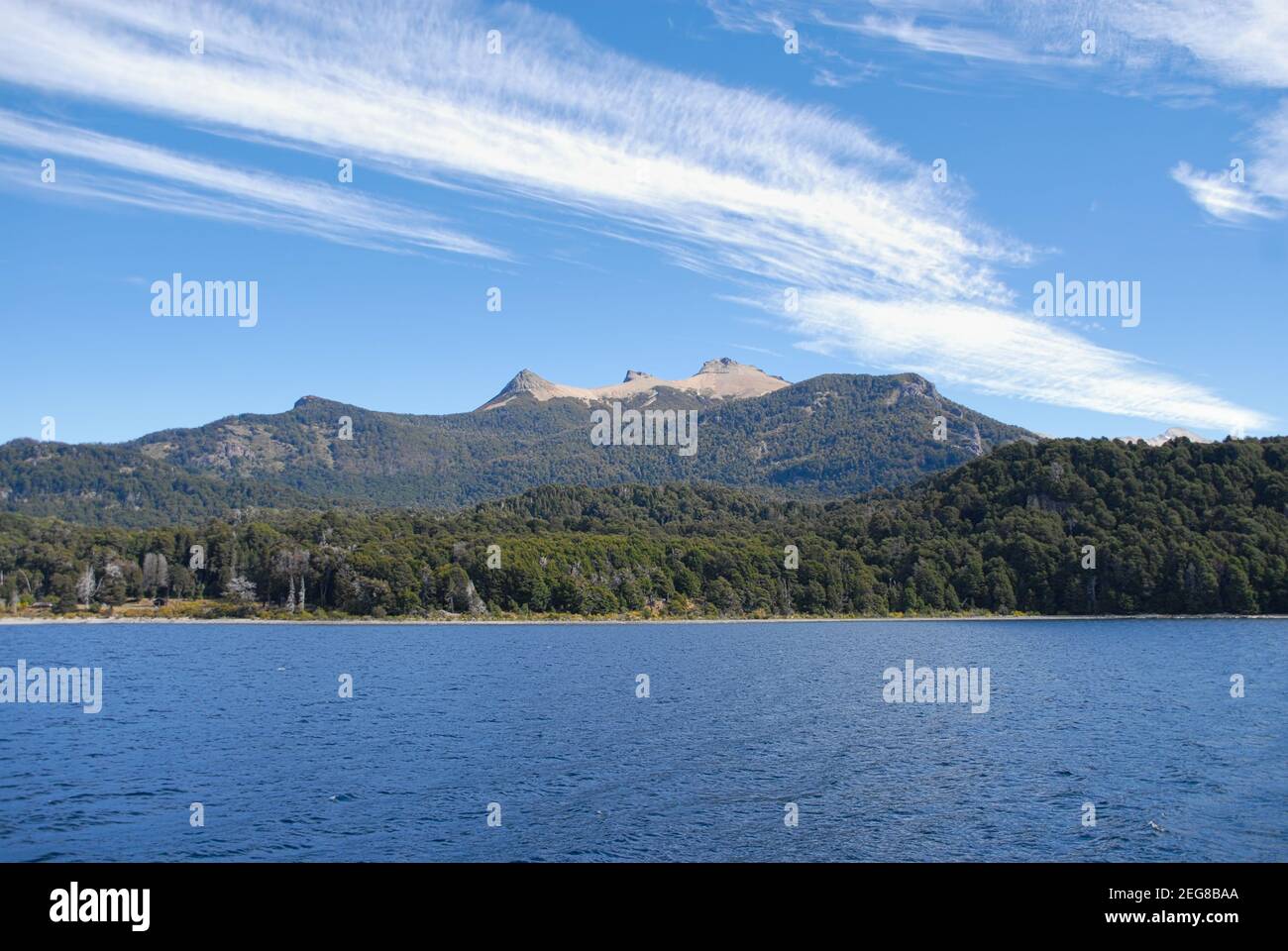 Vista panoramica di un lago con montagne sullo sfondo con nuvole bianche e cielo blu in Cile. Concetto di viaggio e avventura. Foto Stock