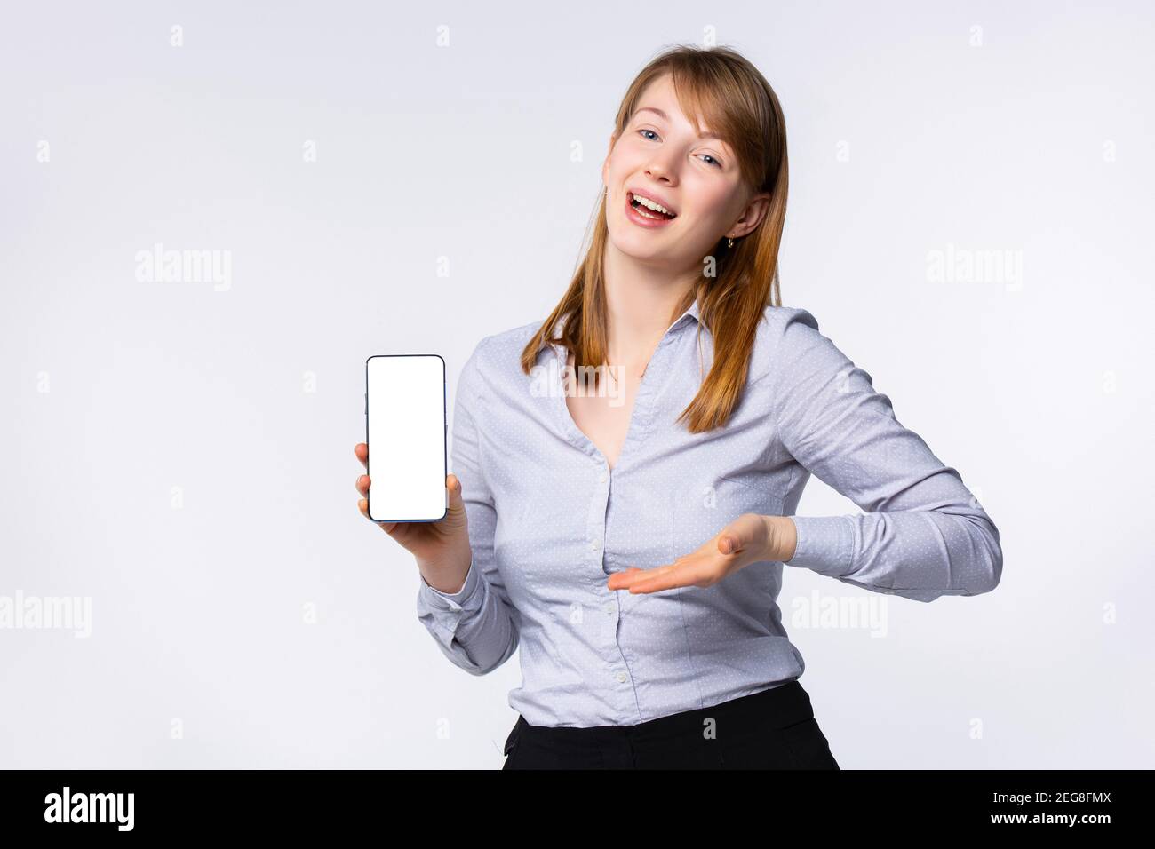 Ritratto di donna bionda felice che mostra schermo bianco di lei smartphone Foto Stock