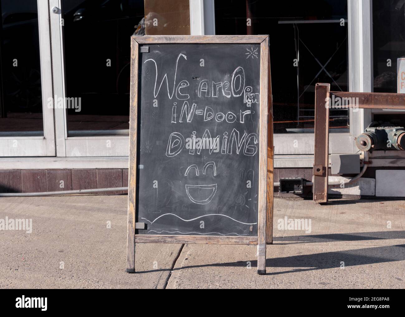 marciapiede cartello lavagna pubblicità un ristorante è aperto al coperto cena a new york durante la covid-19 o pandemia di coronavirus Foto Stock