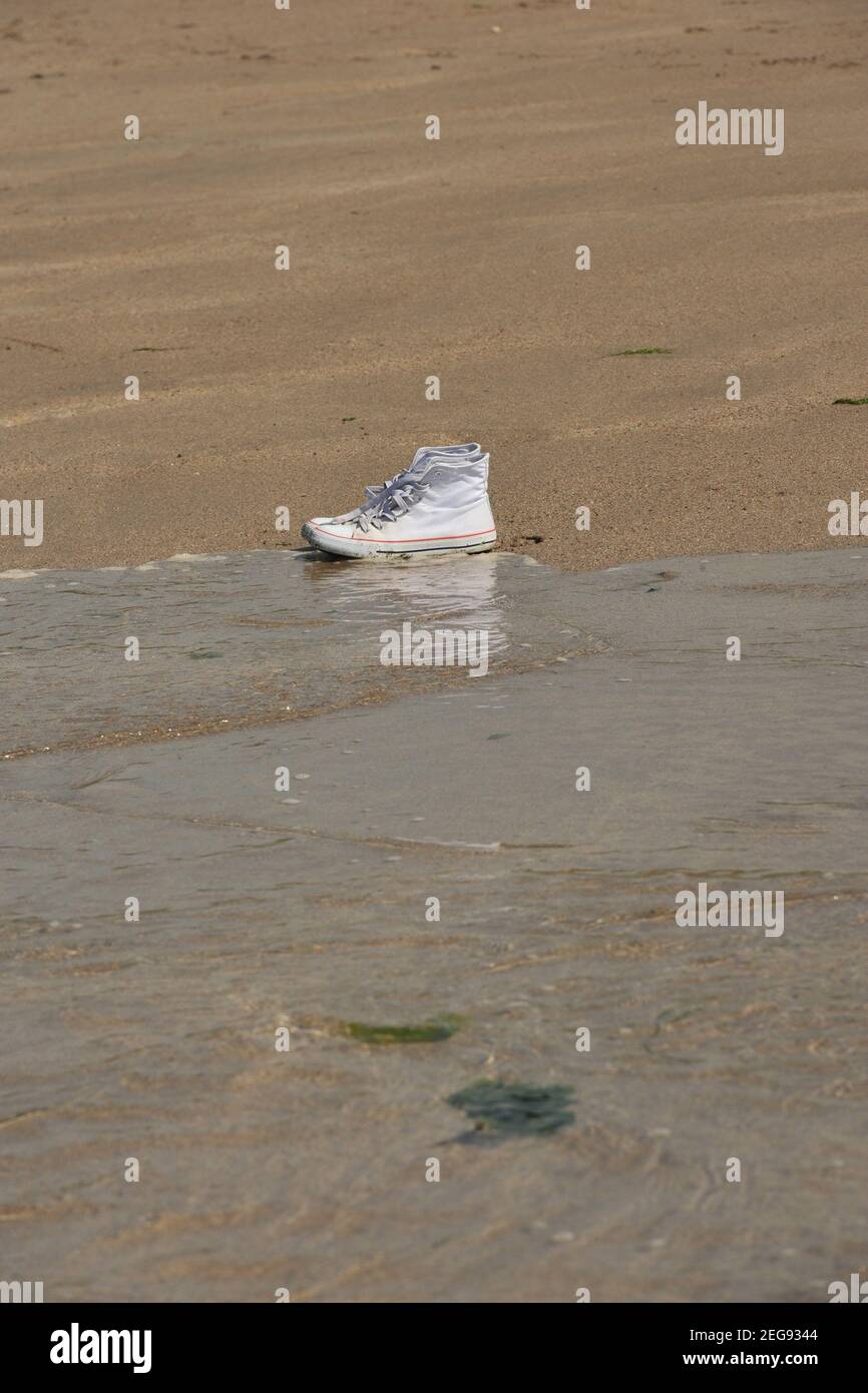 scarpe abbandonate sulla spiaggia Foto Stock