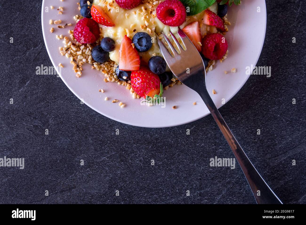 Metà di un piatto dall'alto con frutta fresca e. Budino proteico Foto Stock