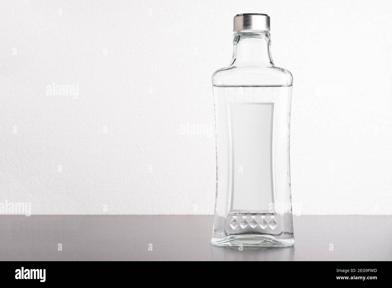 Bottiglia trasparente di vino o acqua davanti a sfondo bianco, modello di serie mock-up modificabile pronto per il tuo progetto, percorso di selezione delle etichette incluso. Foto Stock
