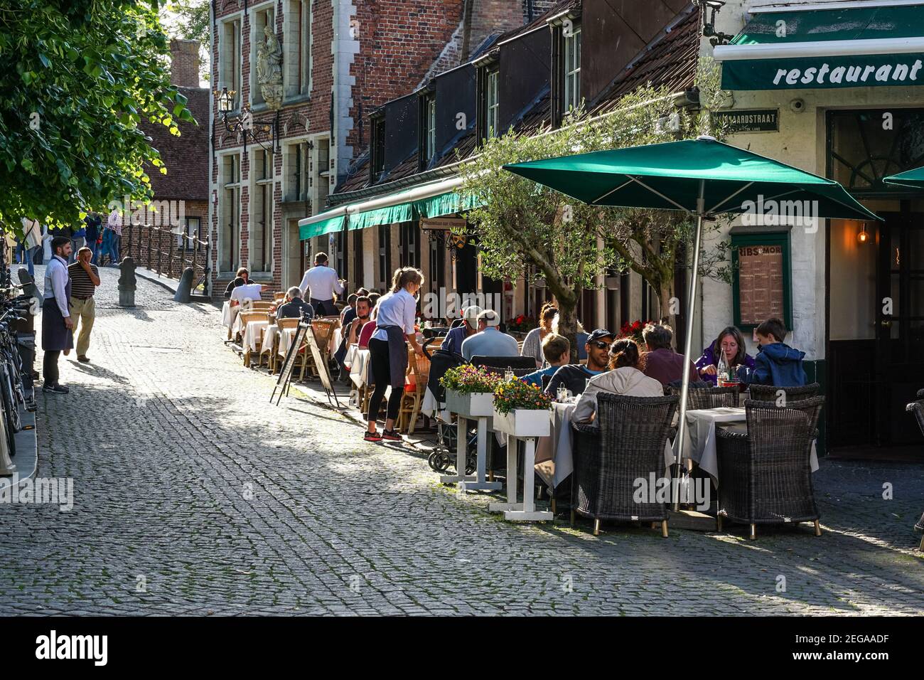 Persone che siedono fuori ristorante a Bruges, Belgio Foto Stock