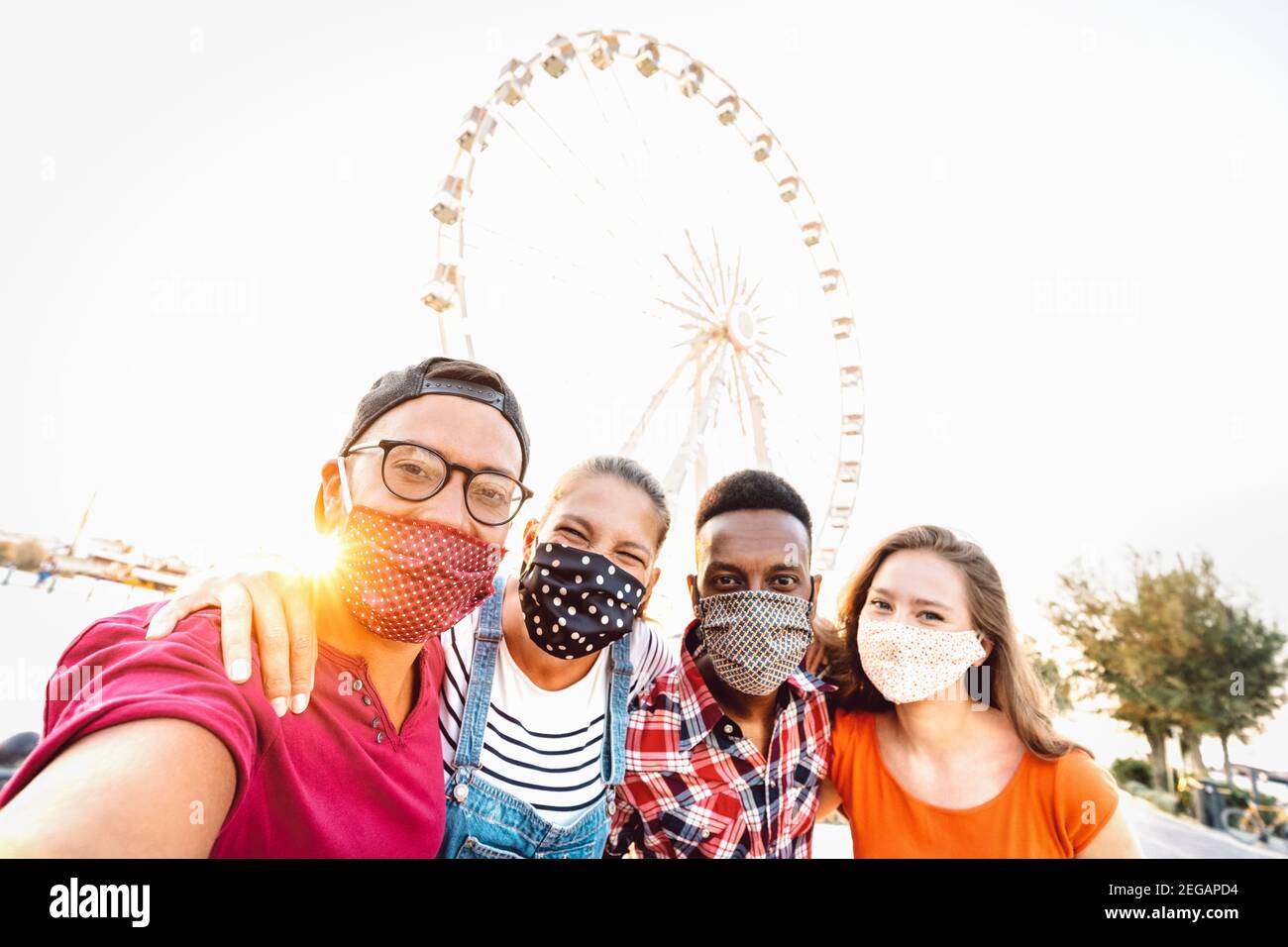 Studenti mileniali multirazziali che prendono selfie protetti da maschere facciali - Nuovo concetto di viaggio normale con i giovani che si divertono in tutta sicurezza insieme Foto Stock