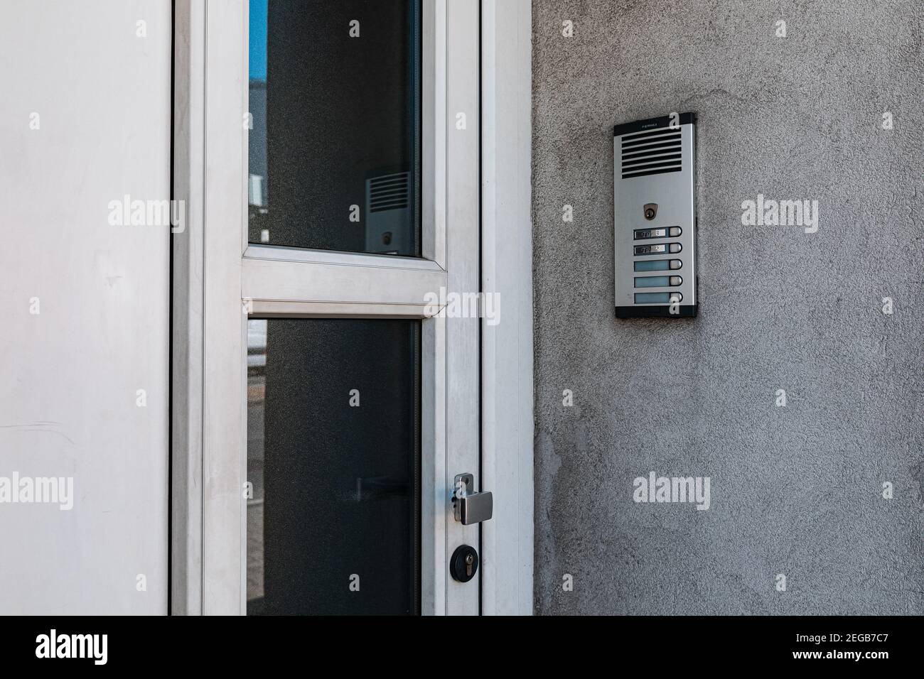 interfono su una parete grigia accanto allo sportello anteriore sulla strada Foto Stock