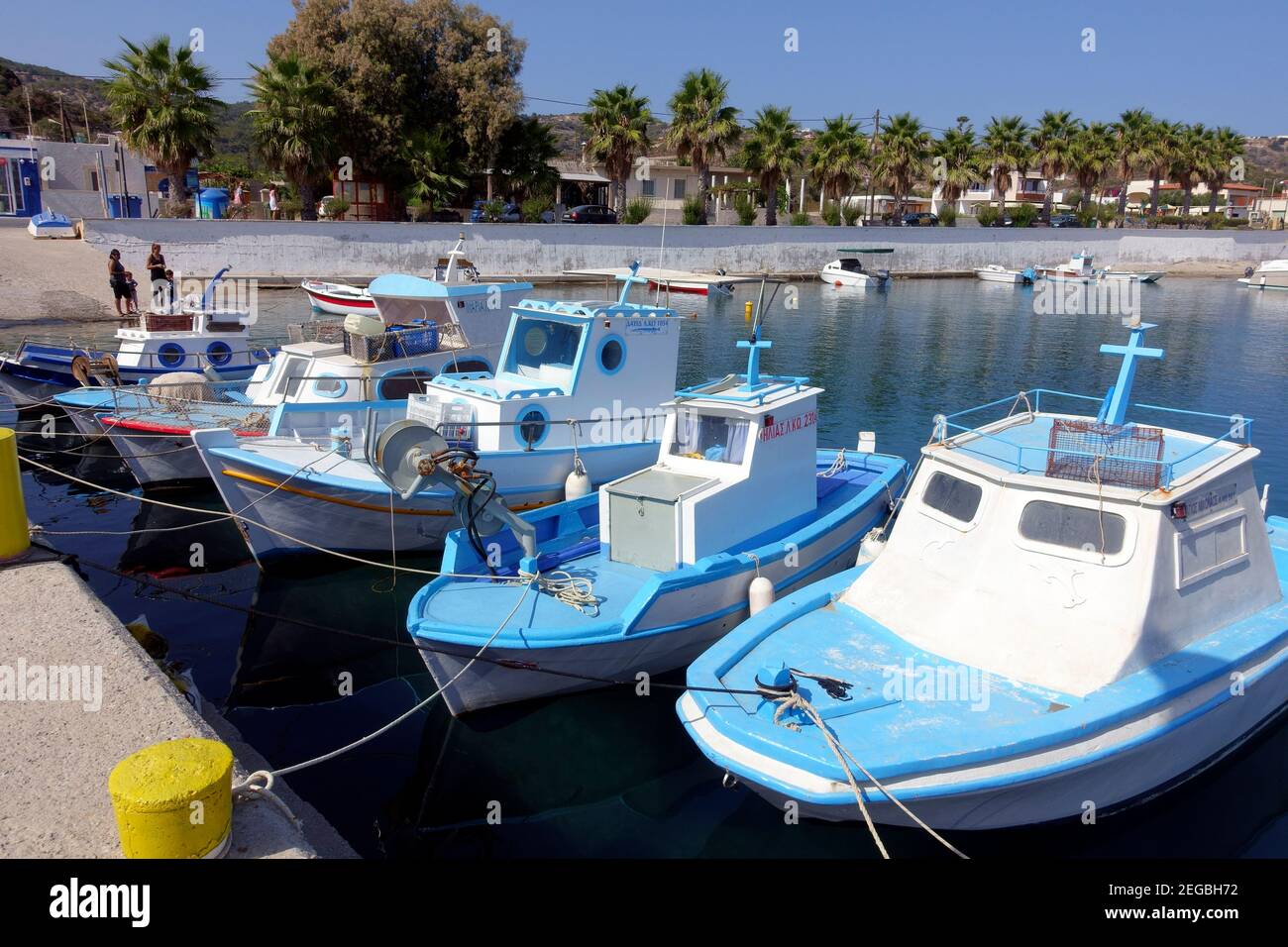 Barche da pesca blu e bianche allacciate nel porto di Kefalos Sull'isola greca di Kos Foto Stock