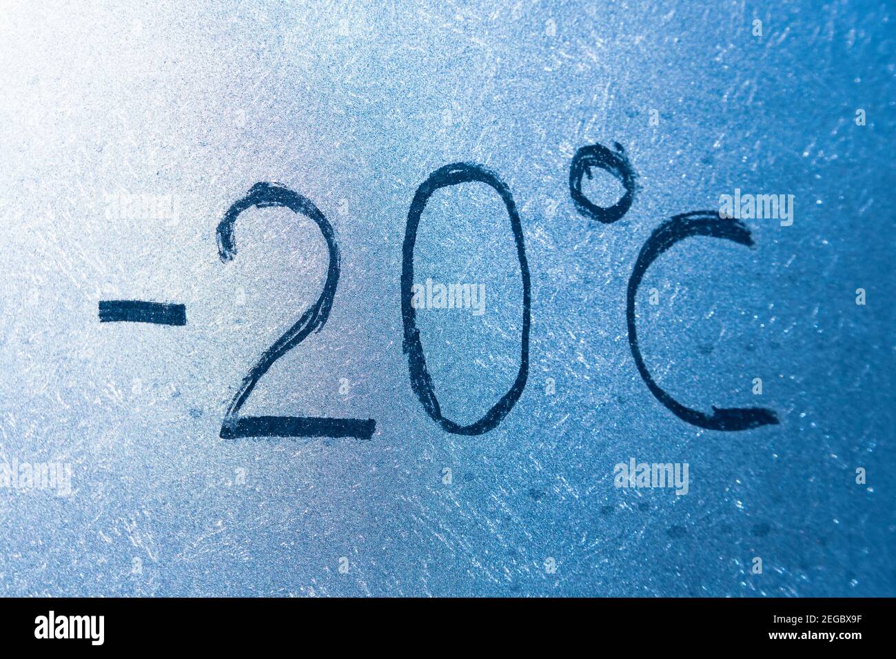 -4 gradi Fahrenheit o -20 gradi Celsius scritta su vetro ghiacciato coperto di ghiaccio e gelo. Il concetto di freddo estremo Foto Stock