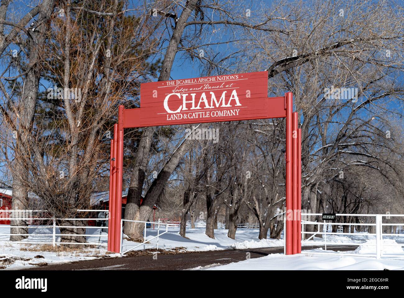 La grande asta di legno rosso con l'insegna per il Lodge a Chama a Chama, New Mexico. Foto Stock