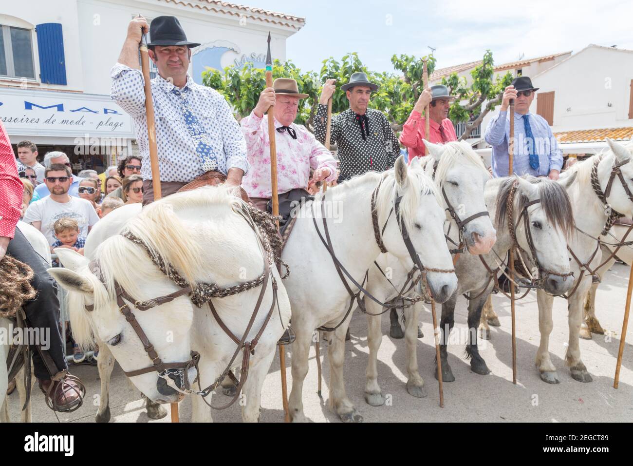 'Les Gardiens Camargaises', in cima ai loro cavalli Camargue aspettare fuori della Chiesa di Saintes Marie de la Mer per la fine del servizio della chiesa e la prosce Foto Stock