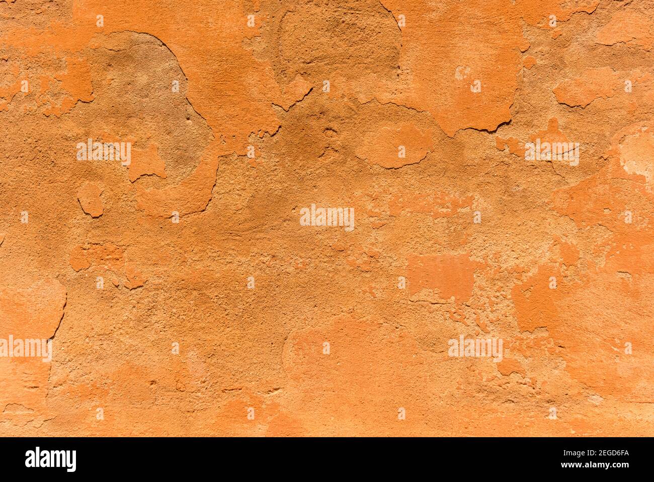 Una parete grintosa e testurizzata dipinta in terracotta che mostra Texture su un muro a Bologna Italia Foto Stock
