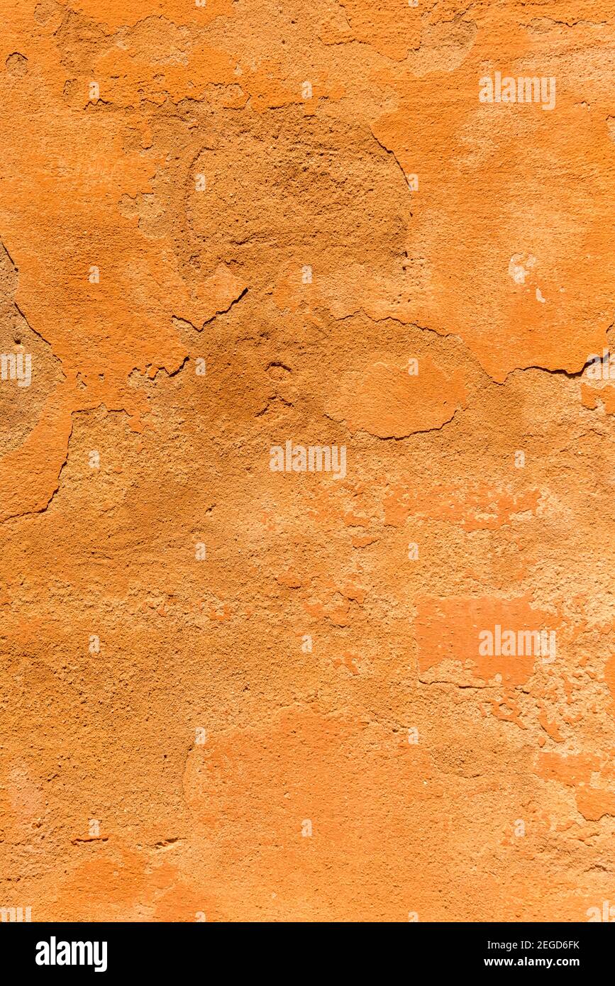 Una parete grintosa e testurizzata dipinta in terracotta che mostra Texture su un muro a Bologna Italia Foto Stock