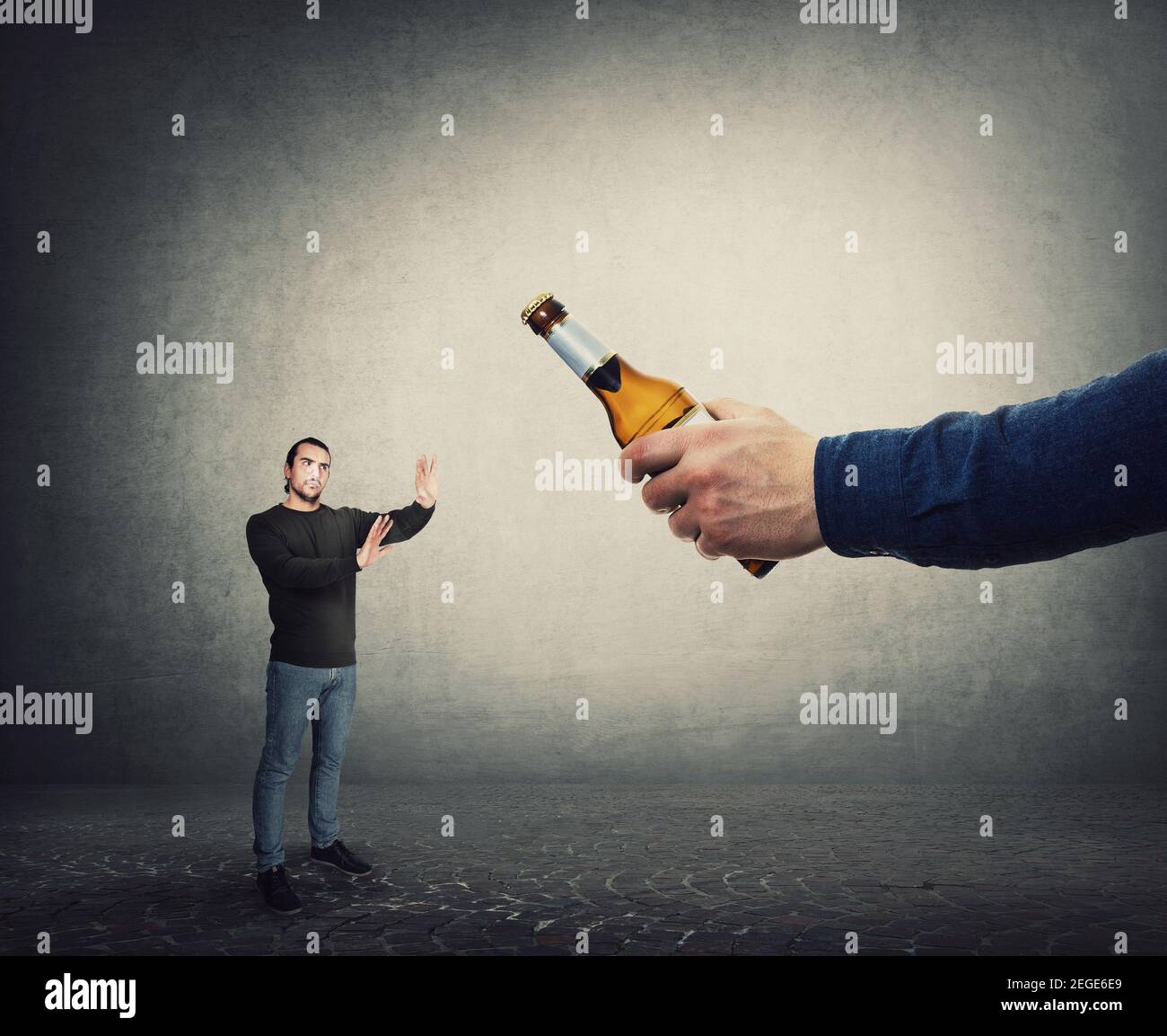 Smettere di consumare alcol concetto. L'uomo rifiuta di prendere una bottiglia di birra da una mano gigante, come metafora per vincere contro la dipendenza. Il ragazzo respinge bere alc Foto Stock