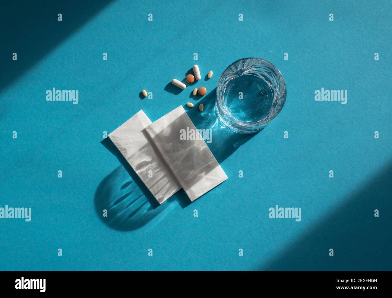 Medicina, acqua e tessuti per un'infezione da corona isolati su sfondo blu con spazio per il testo Foto Stock