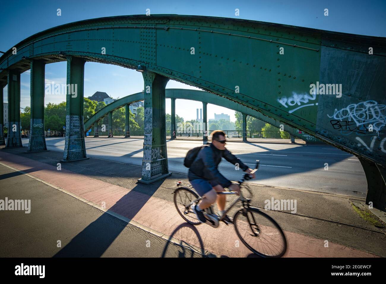 Ciclista che attraversa il Schlossbrücke, Berlino-Charlottenburg, Germania, movimento, ponte d'acciaio e mobilità urbana quotidiana Foto Stock