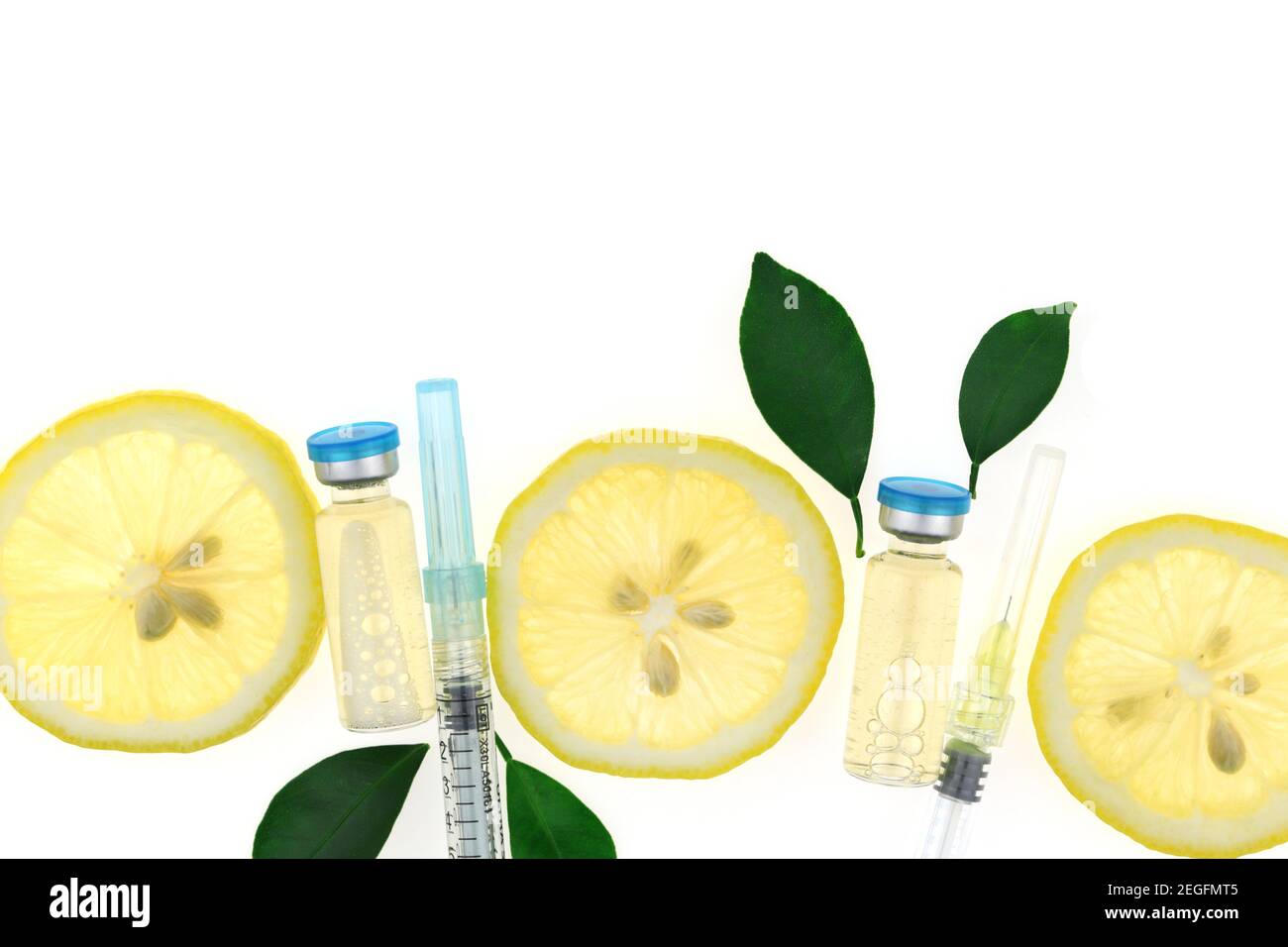 Vitamina C.concetto di salute e bellezza.Apmuli di vetro, siringhe e fette di limone isolati su sfondo bianco. Prevenzione dell'immunità da virus.siero Foto Stock