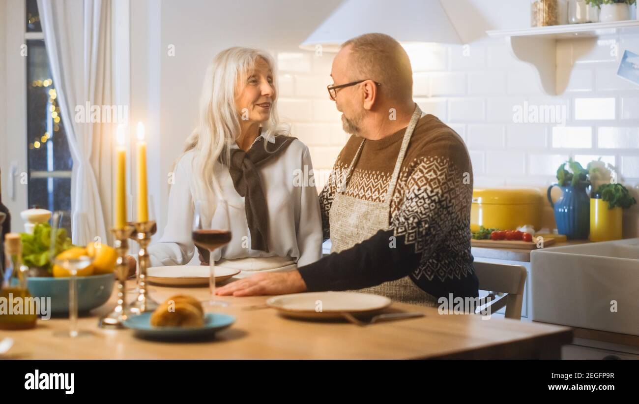 Happy Senior Couple in Love serata romantica, cucina e cena in cucina, festeggiando l'anniversario. Gli anziani hanno una serata romantica Foto Stock