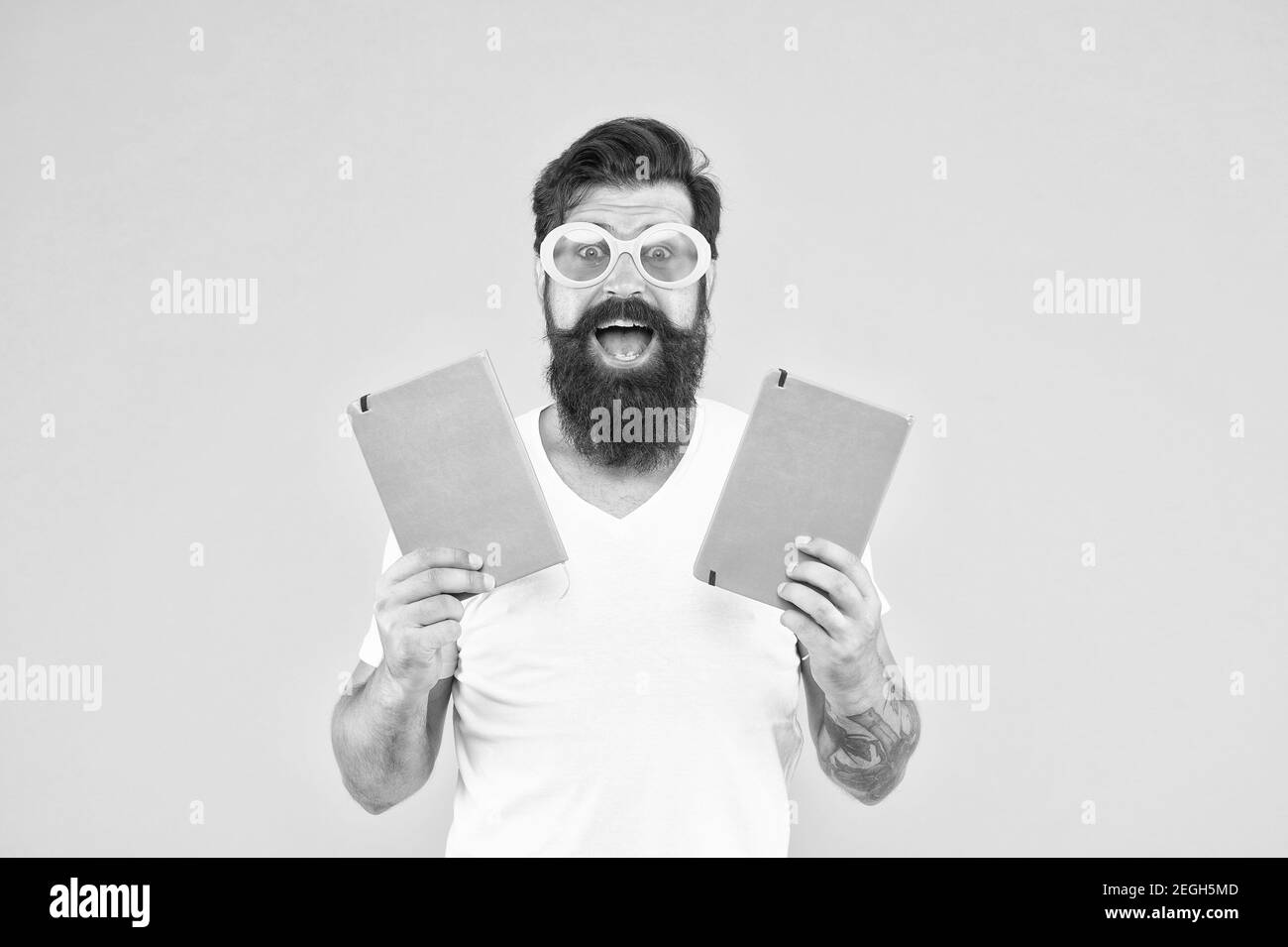 Interessante apprendimento. Imparare è divertente. Studiare con piacere. Buon divertimento. Imparare con felicità. Divertente uomo adulto allegro in occhiali da sole tenere libri. Studiare all'università. Positivo ed energetico. Foto Stock