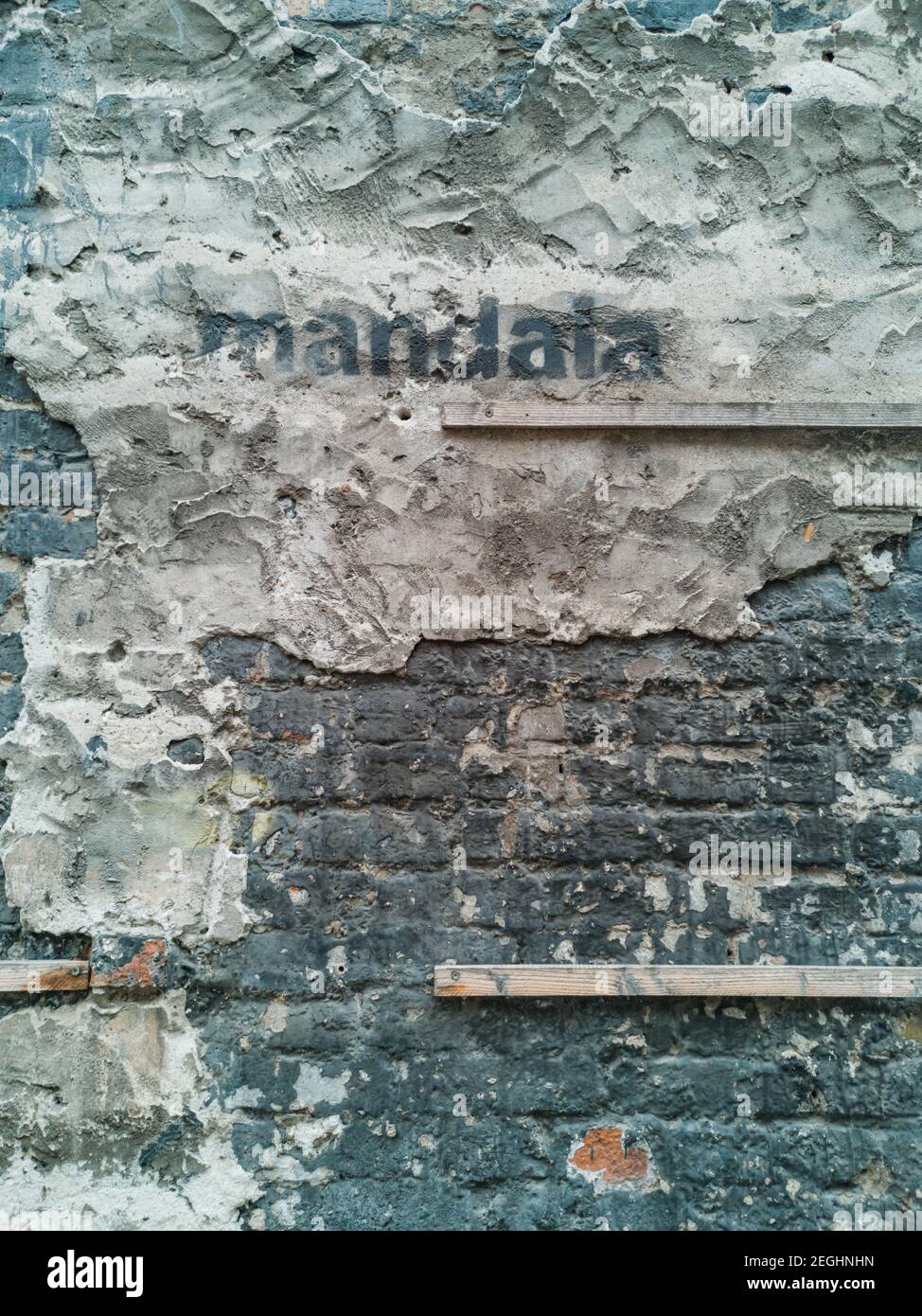 Grunge muro di edificio con legno di cemento e tegole spruzzato parola Foto Stock