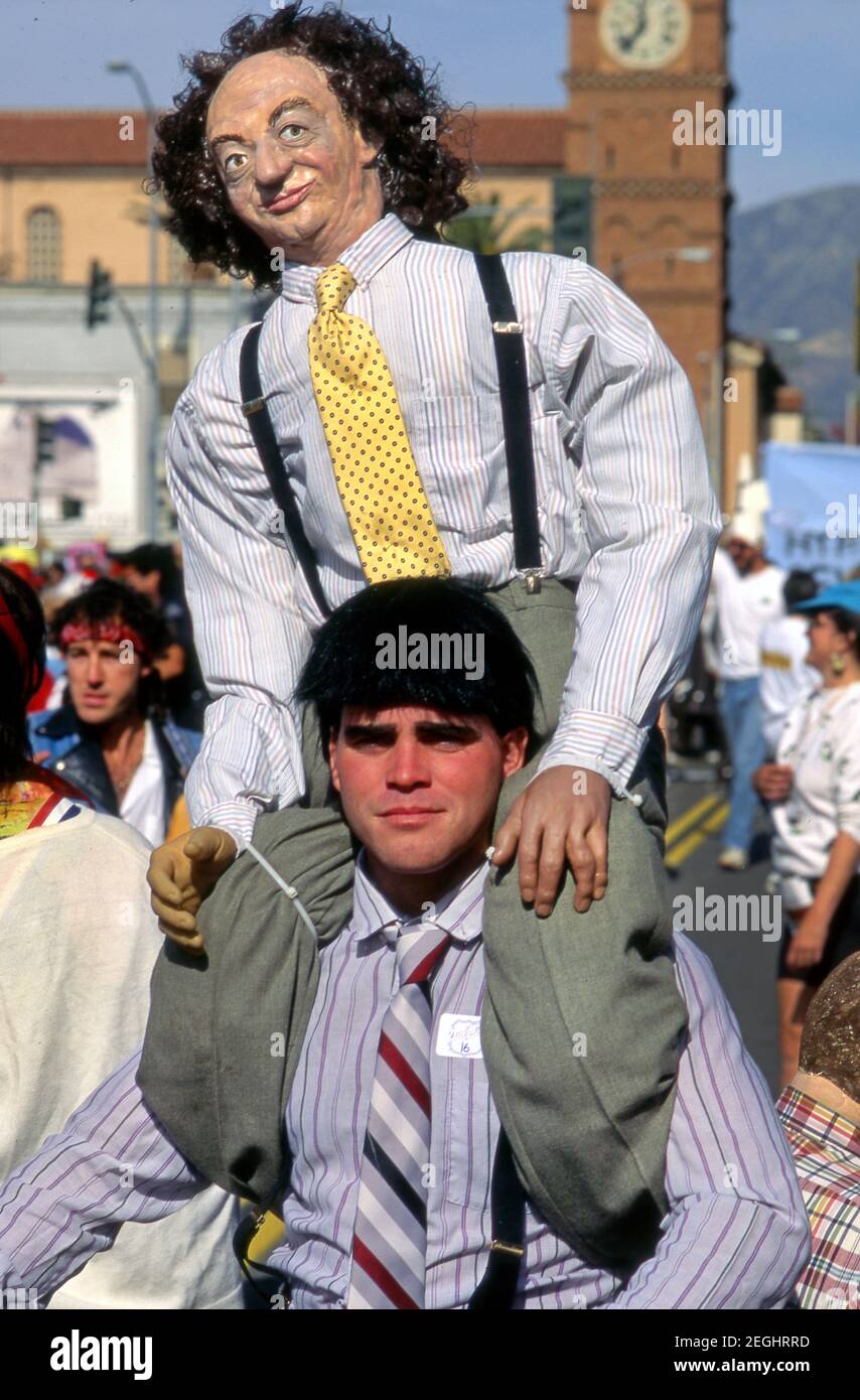 Uomo vestito come Moe dei tre Stooges con una figura di Larry sulle sue spalle al Doo Dah Parade a Pasadena, CA Foto Stock