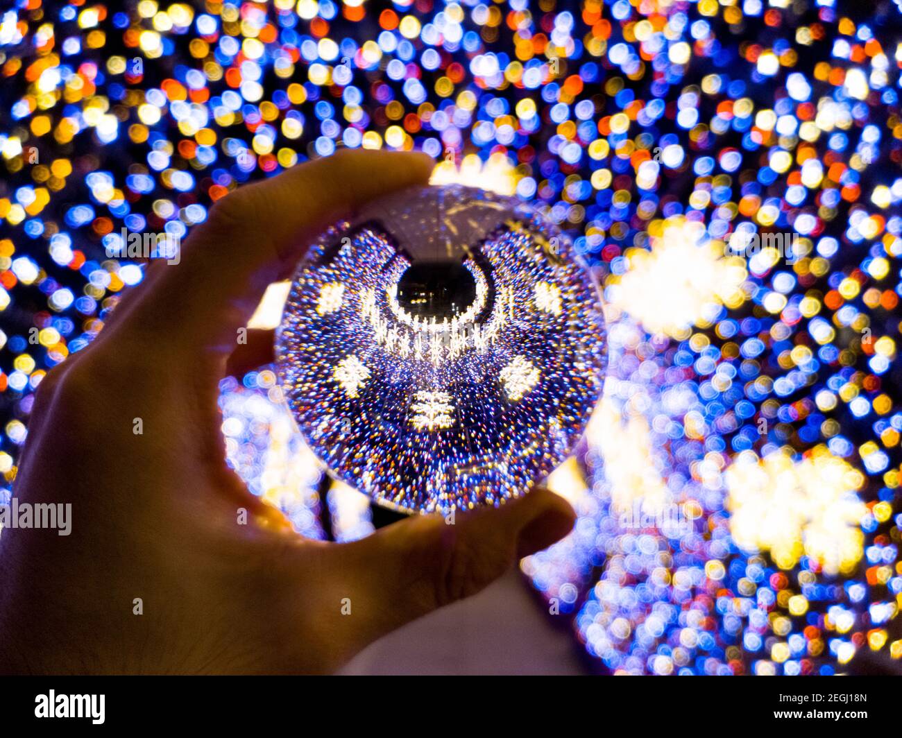 Tunnel di natale rotondo colorato fatto di luci di natale riflesse in lensball cristallo vetroso Foto Stock