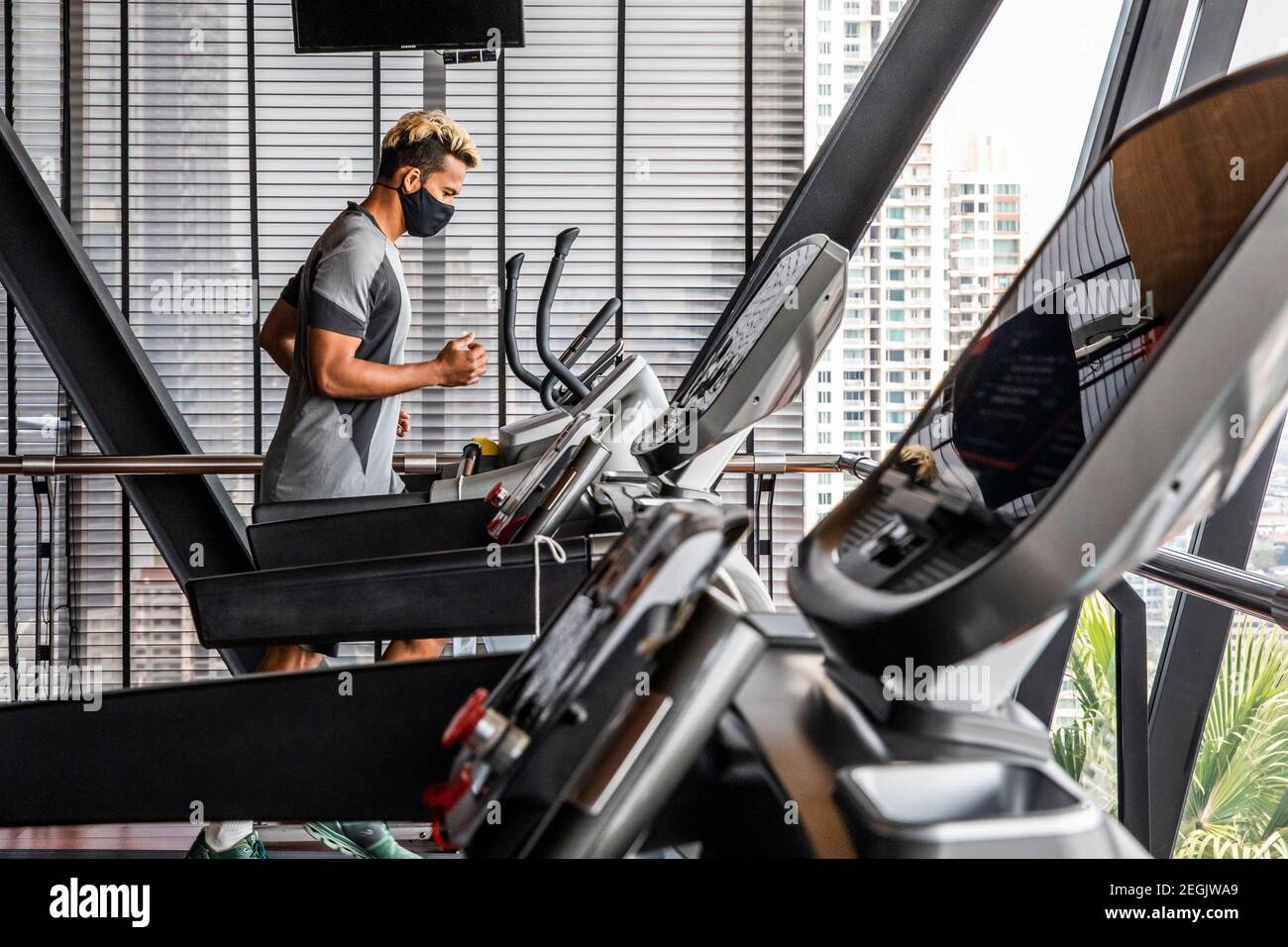 Fitness Trainer dimostra sicurezza con maschera e Social Distancing Foto Stock