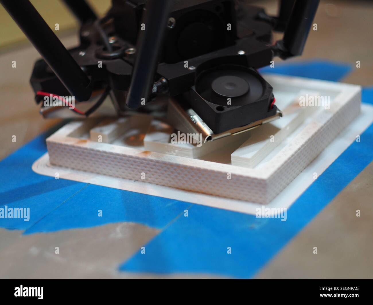 Stampa 3D in abs bianco una texture su nastro blu attaccato al letto di calore, ventole che funzionano alla massima velocità Foto Stock