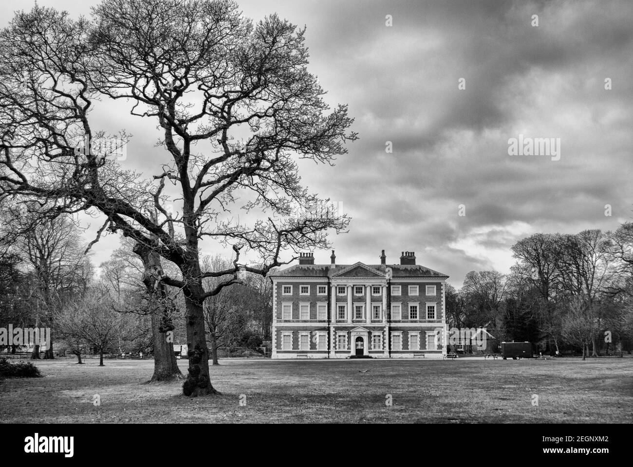 Lytham Hall di grado 1 casa di campagna con albero, terreni e nuvole in bianco e nero Foto Stock