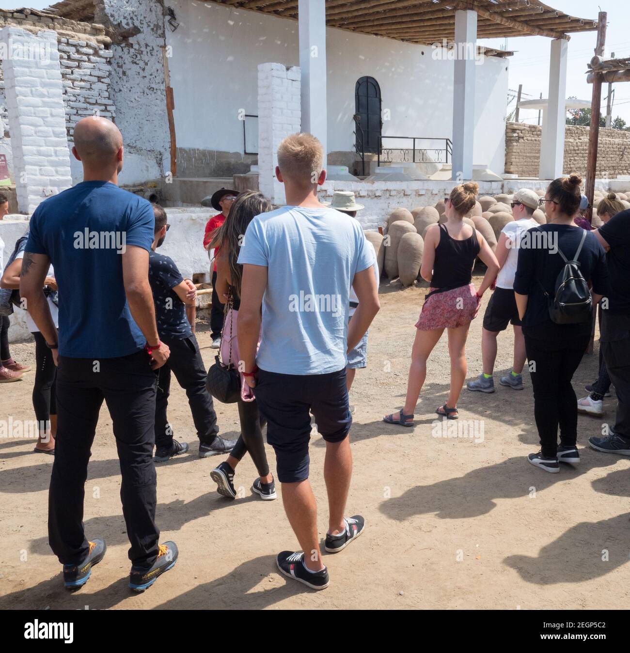 Peru Ica - 22 settembre 2019 - El catador Winery tour, gruppo di persone ascolta la guida, due uomini in t-shirt blu, vasi di distilleria sul pavimento Foto Stock
