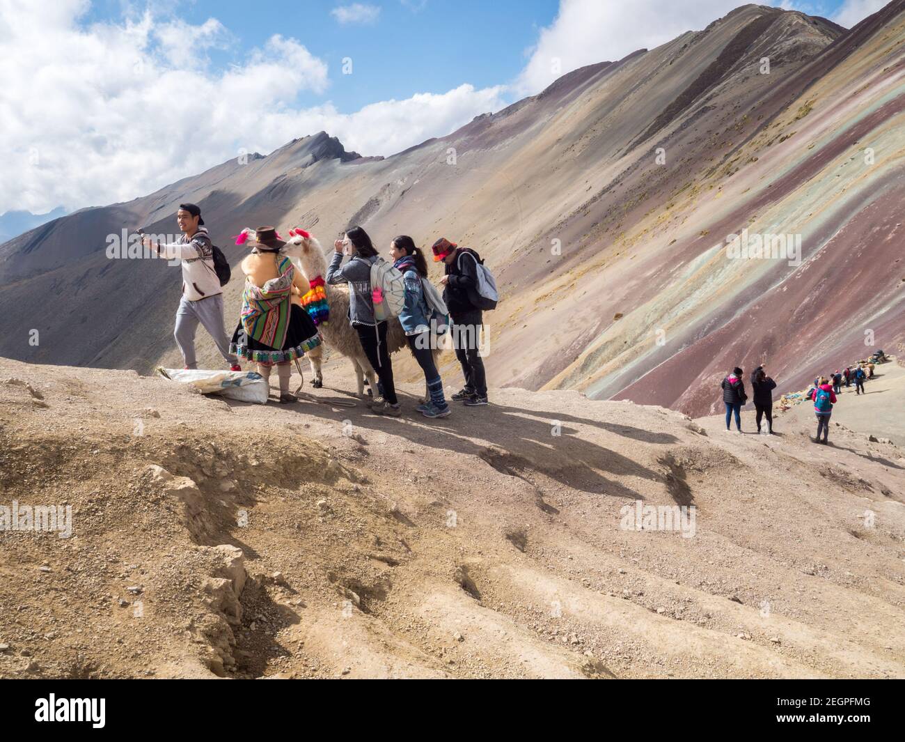 Perù, Vinicunca - 27 settembre 2019 - i turisti asiatici prendono selfie con lama sulla montagna arcobaleno Foto Stock