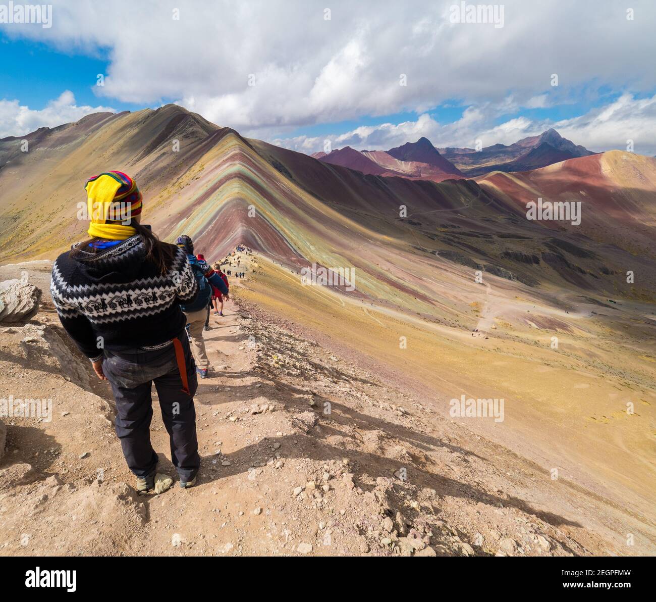 Perù, Vinicunca - 27 settembre 2019 - l'uomo in abiti indiani gode della vista della montagna arcobaleno, cappello giallo Foto Stock