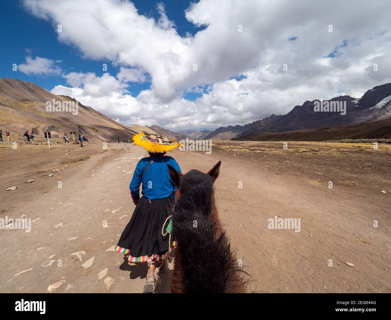 Perù, Vinicunca - 1 ottobre 2019 - turisti locali di trasporto indiano su e giù montagna arcobaleno sui cavalli Foto Stock