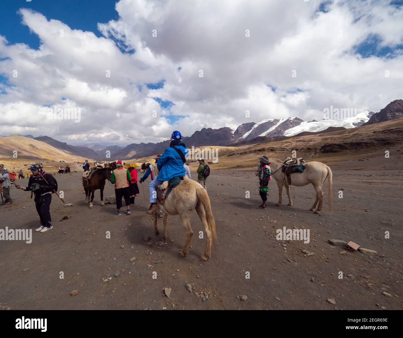 Perù, Vinicunca - 1 ottobre 2019 - cavalli, turisti e locali sulle montagne delle Ande in Perù, neve montagna in lontananza Foto Stock