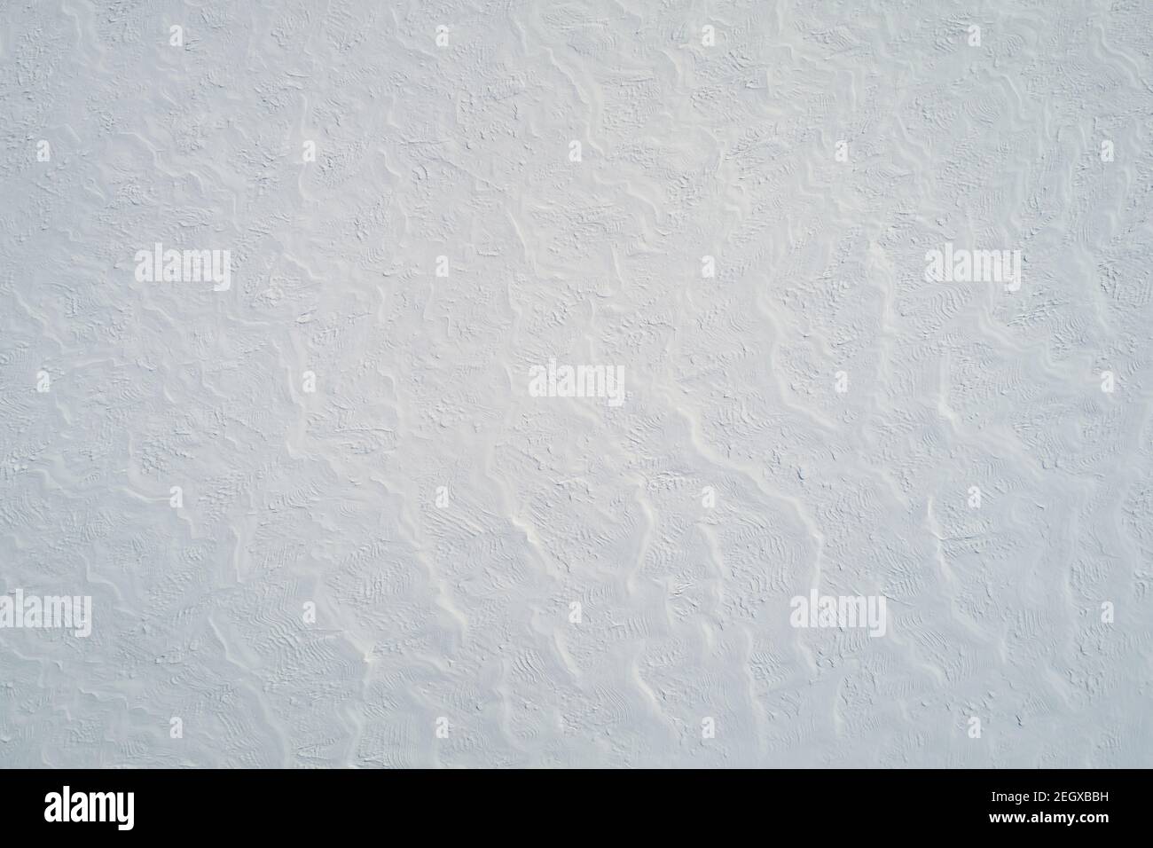 Disegno di superficie del campo di neve aerialsopra il dron vista su luminoso giorno di sole Foto Stock