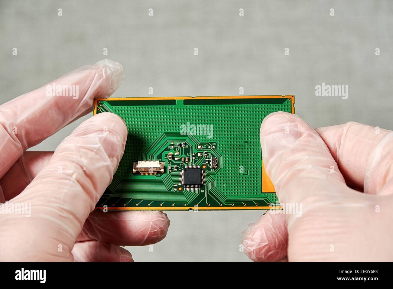 Un ingegnere tiene il PCB con un microchip nelle sue mani dopo lo sviluppo. Nanotecnologia e laboratorio di fabbricazione Foto Stock