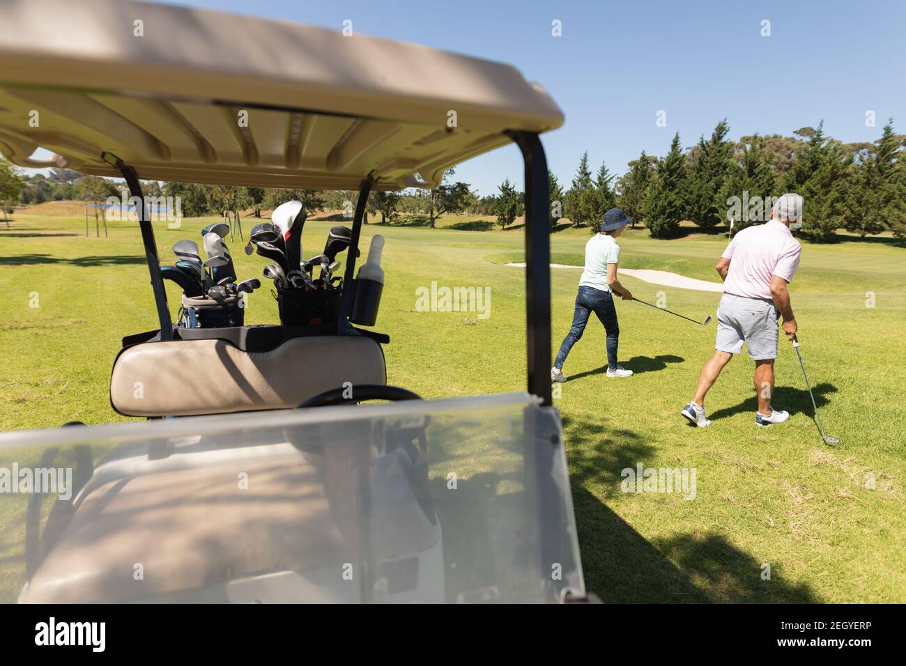 Uomo e donna caucasica che si allontana dalla tenuta della baggie golf club Foto Stock