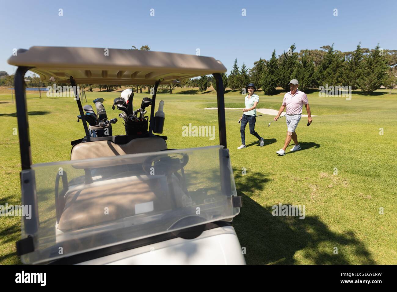 Uomo e donna caucasica che si allontana dalla tenuta della baggie golf club Foto Stock