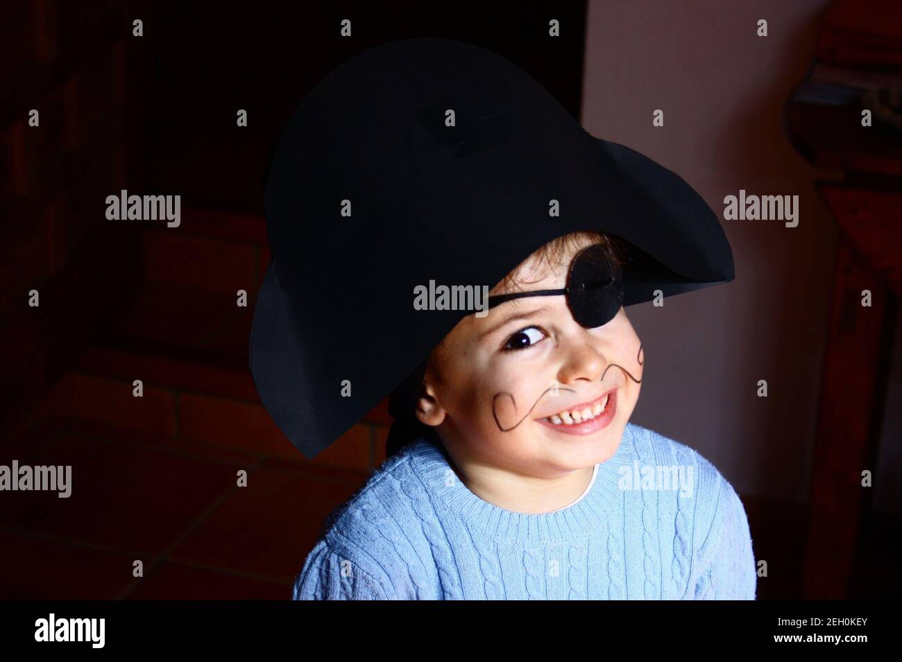 Un ragazzo felice che indossa un costume pirata. Sfondo nero. Foto Stock