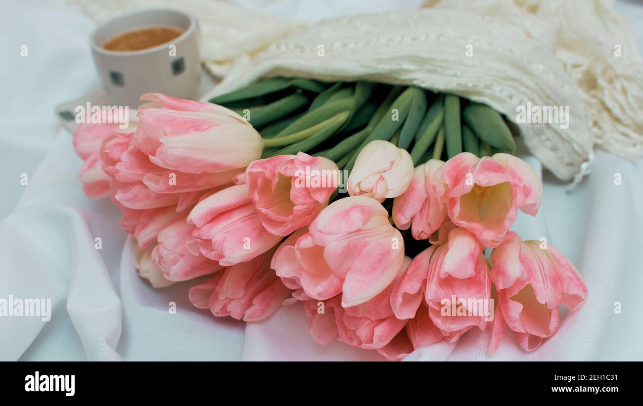 Un bouquet di delicati tulipani di rose. Una tazza di caffè aromatico. 8 carta giorno mertà o madri Foto Stock