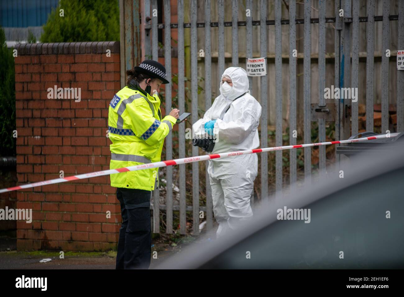 Handsworth, Birmingham, West Midlands, Regno Unito. 19 febbraio 2021: L'ufficiale di polizia femminile prende appunti da un investigatore forense. Un uomo è morto dopo una beatola in una proprietà su Church Hill Road intorno alle 5:20 venerdì mattina. Gli ufficiali di Forensics hanno combattuto la casa e una tenda blu rimane fuori della proprietà. Credit: Ryan Underwood / Alamy Live News. Foto Stock