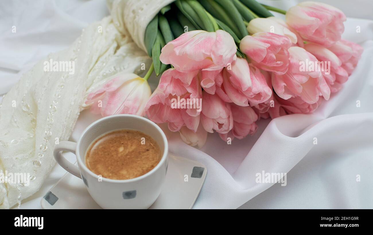 Un bouquet di delicati tulipani di rose. Una tazza di caffè aromatico. 8 carta giorno mertà o madri Foto Stock