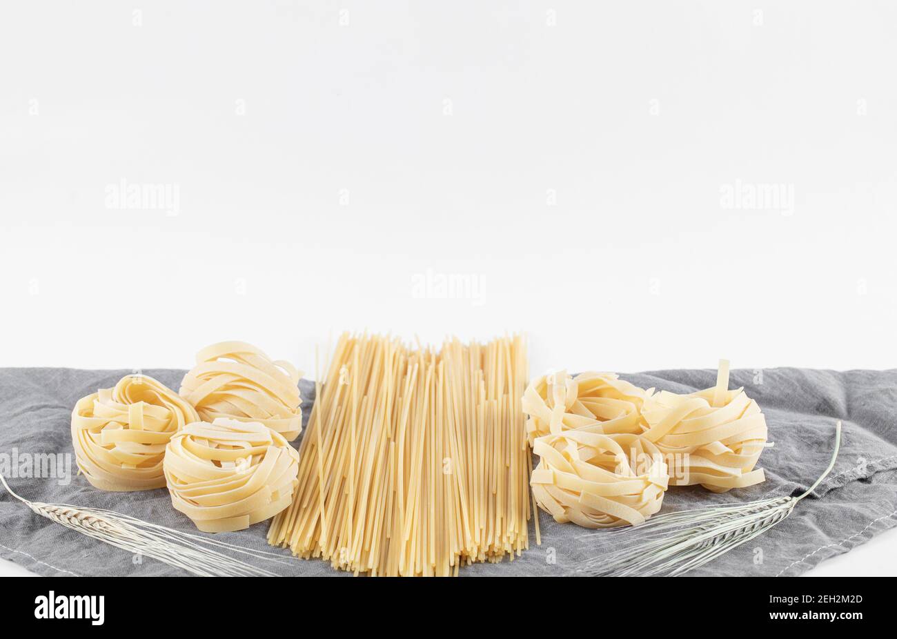 Varietà di pasta cruda su tovaglia grigia Foto Stock