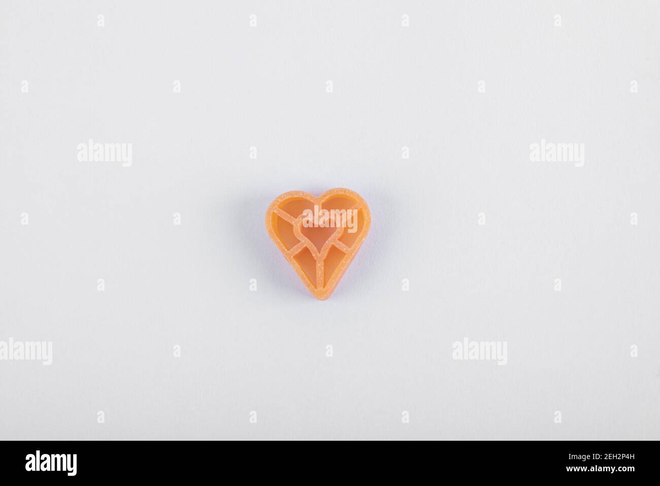 Pasta a forma di cuore singolo su sfondo bianco Foto Stock