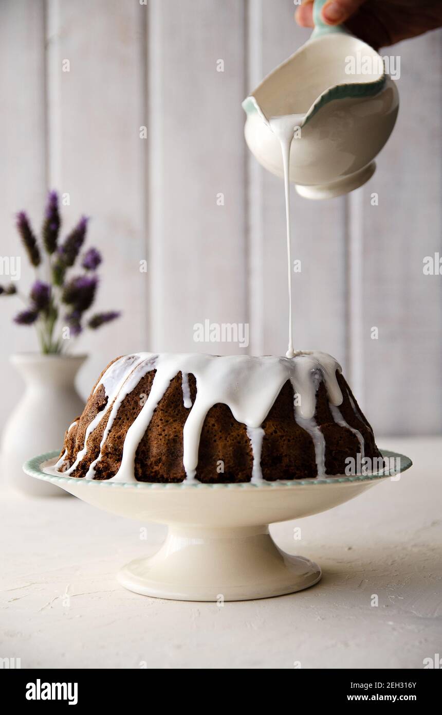 Torta al cioccolato con glassa di merletto, fiori di lavanda e sfondo bianco. Foto Stock