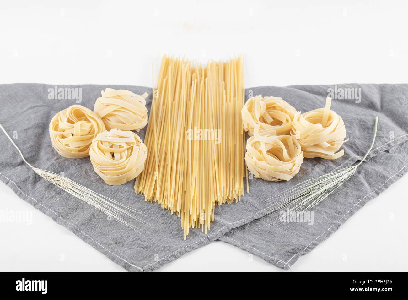 Varietà di pasta cruda su tovaglia grigia Foto Stock