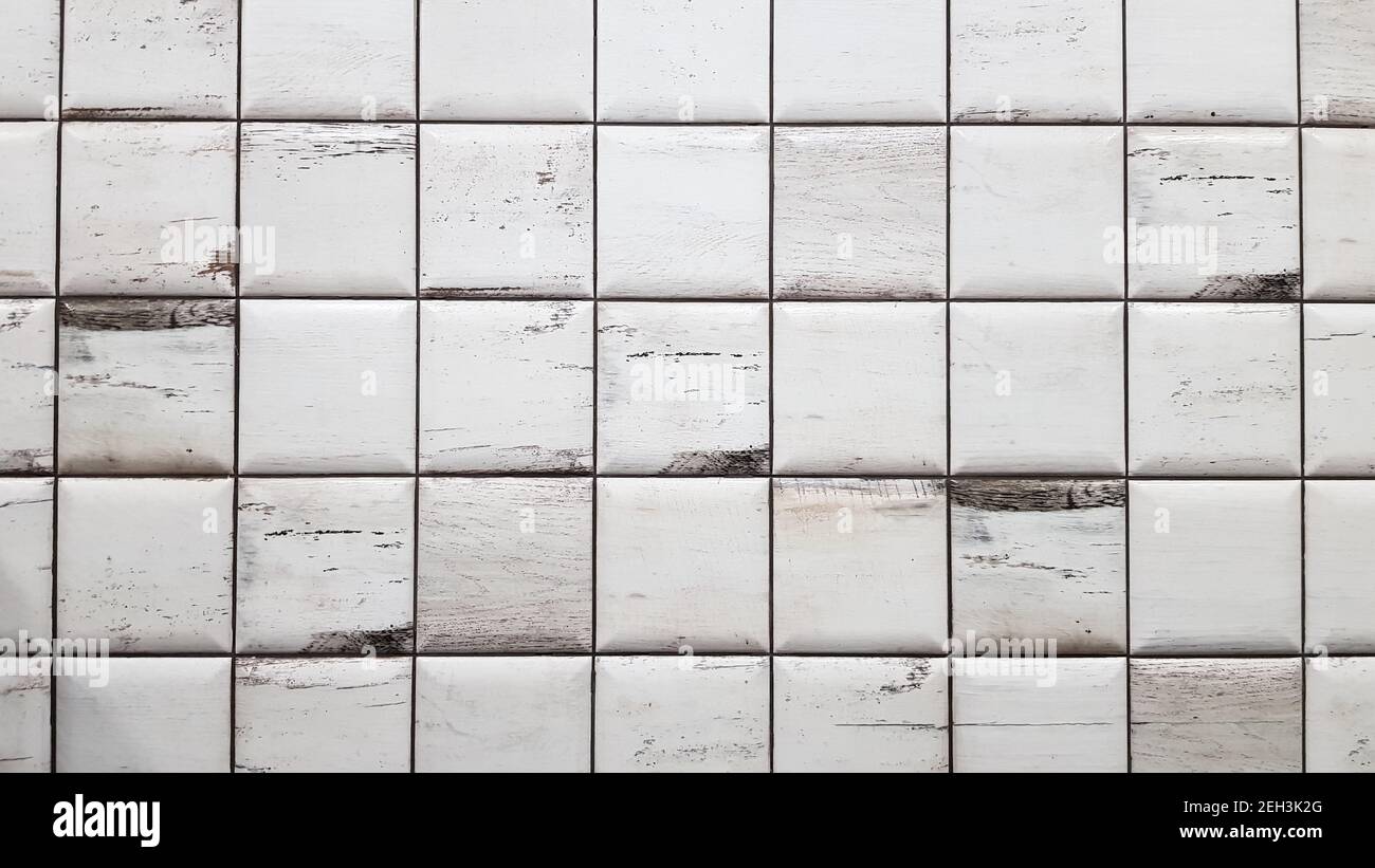 Sfondo bianco piastrelle invecchiate. Piastrelle a trama senza giunture. Vecchie piastrelle bianche piccole quadrate sporche sulla parete Foto Stock