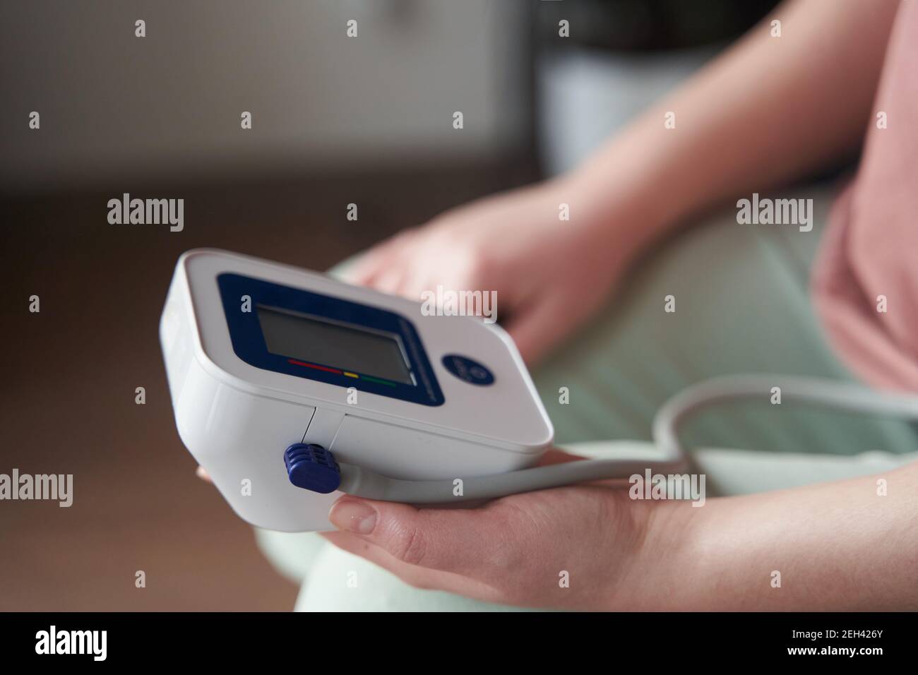 una giovane ragazza misura la sua pressione sanguigna con un tonometro Foto Stock