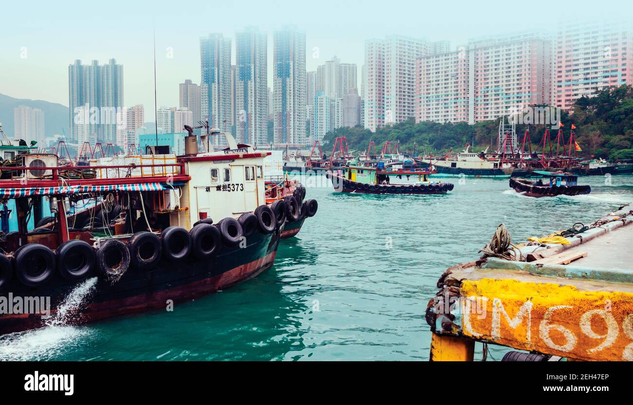 Hong Kong, Cina. Porto di Aberdeen. Barche da pesca e blocchi di appartamenti alti. Foto Stock